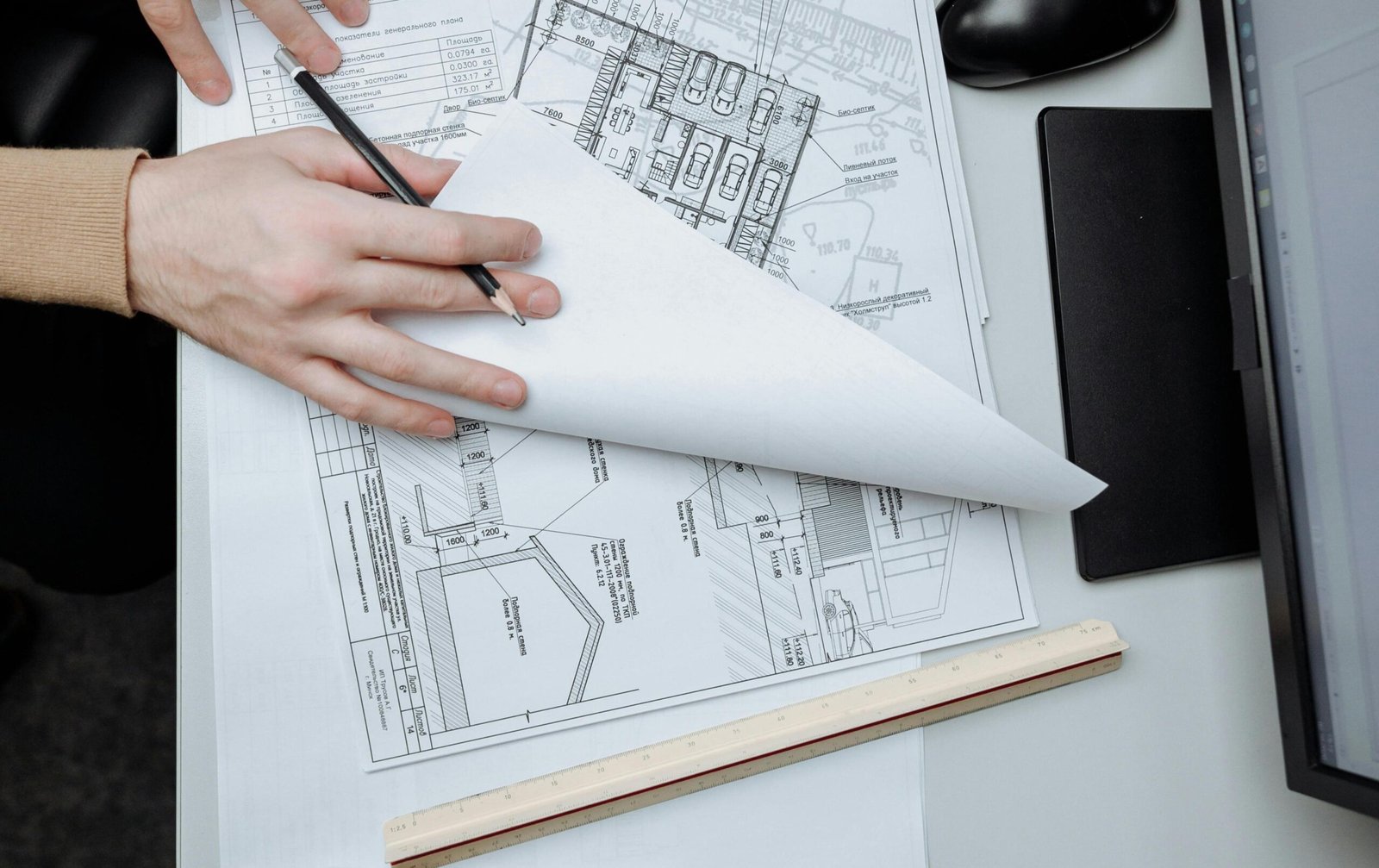 Alt: "manos de arquitecto haciendo un plano"